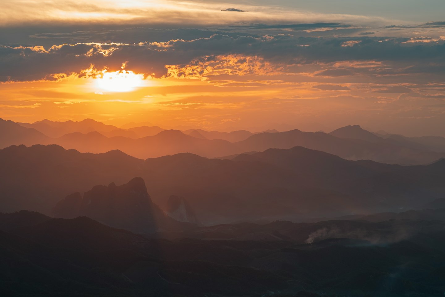 Sagome di catene montuose contro un cielo al tramonto.