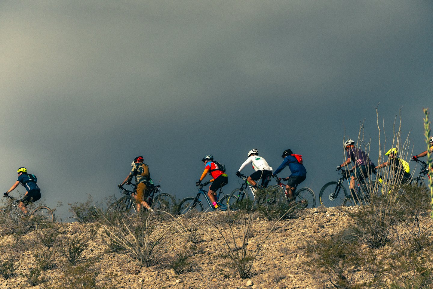 Ciclisti di montagna salgono su un sentiero roccioso nel deserto.